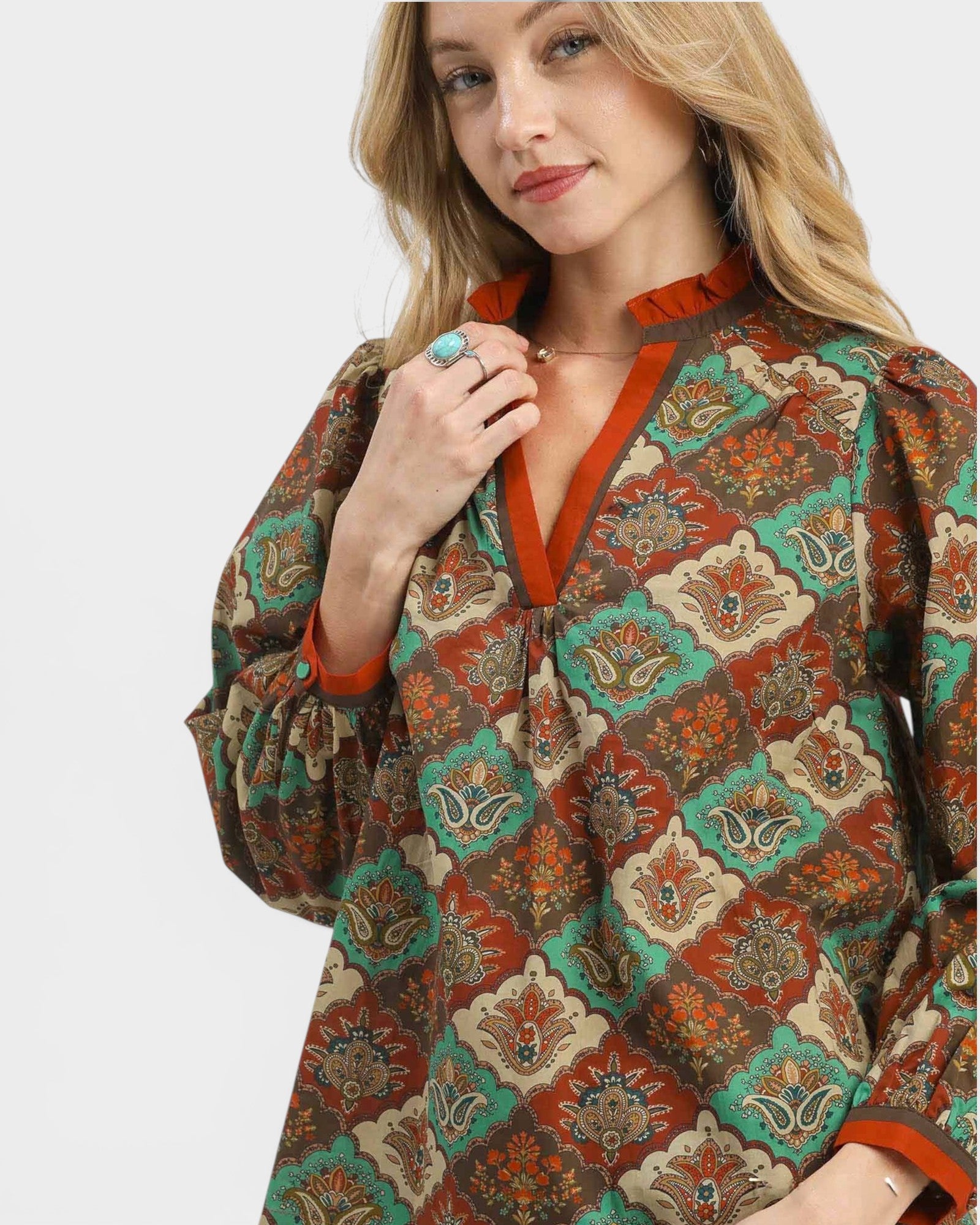 Woman wearing a patterned blouse with a white background