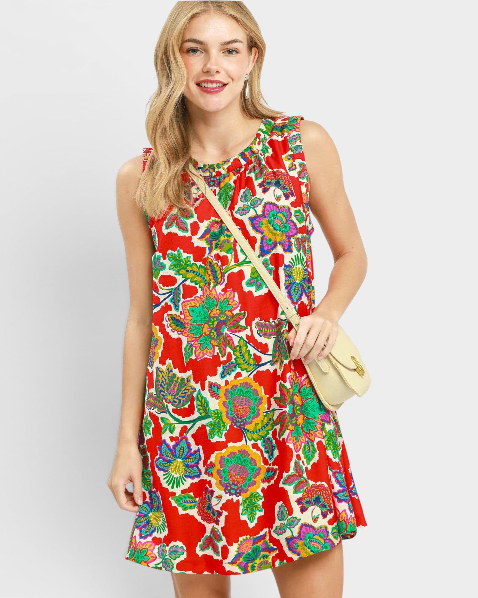 Woman wearing a colorful floral dress with a plain background
