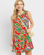 Woman wearing a colorful floral dress with a plain background