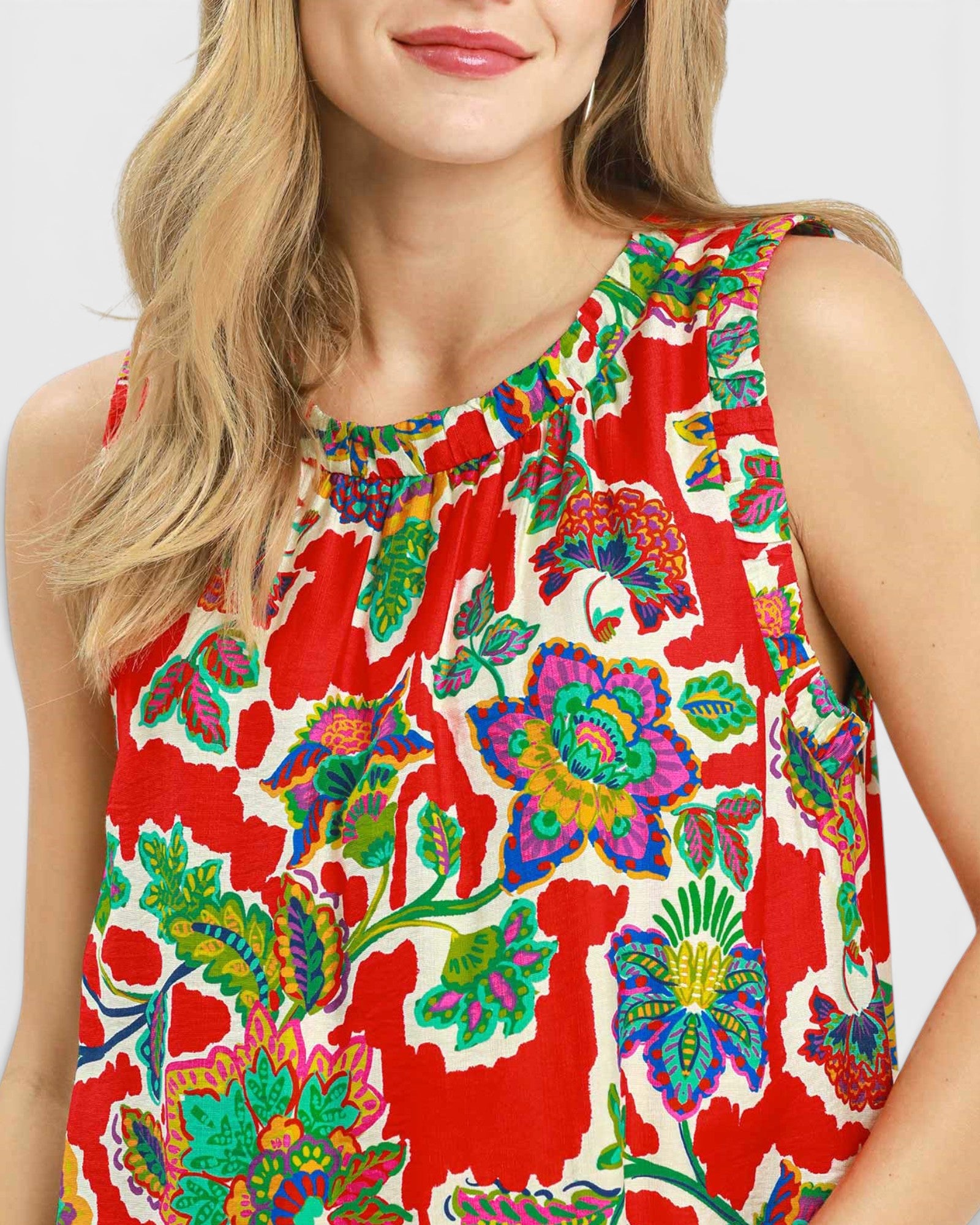 Woman wearing a colorful floral dress with a red background