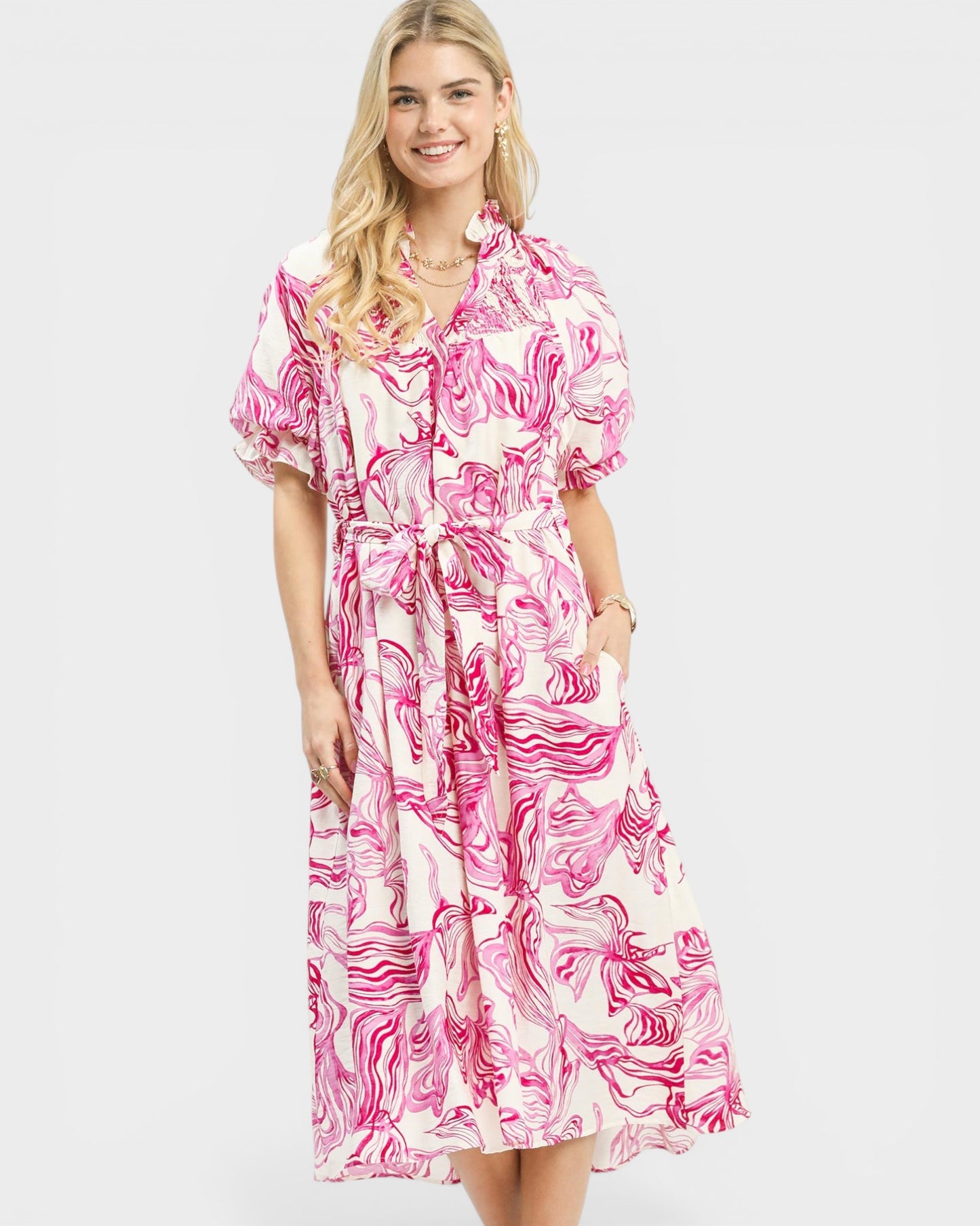 Woman wearing a pink and white floral dress on a white background