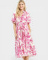 Woman wearing a pink and white floral dress on a white background