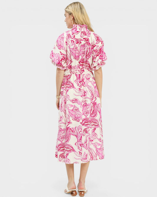 Woman wearing a pink and white floral dress on a white background