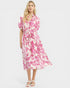 Woman wearing a pink and white floral dress on a white background