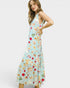 Woman wearing a light blue dress with colorful fruit pattern on a white background