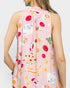 Woman wearing a sleeveless dress with colorful fruit and dessert pattern on a white background