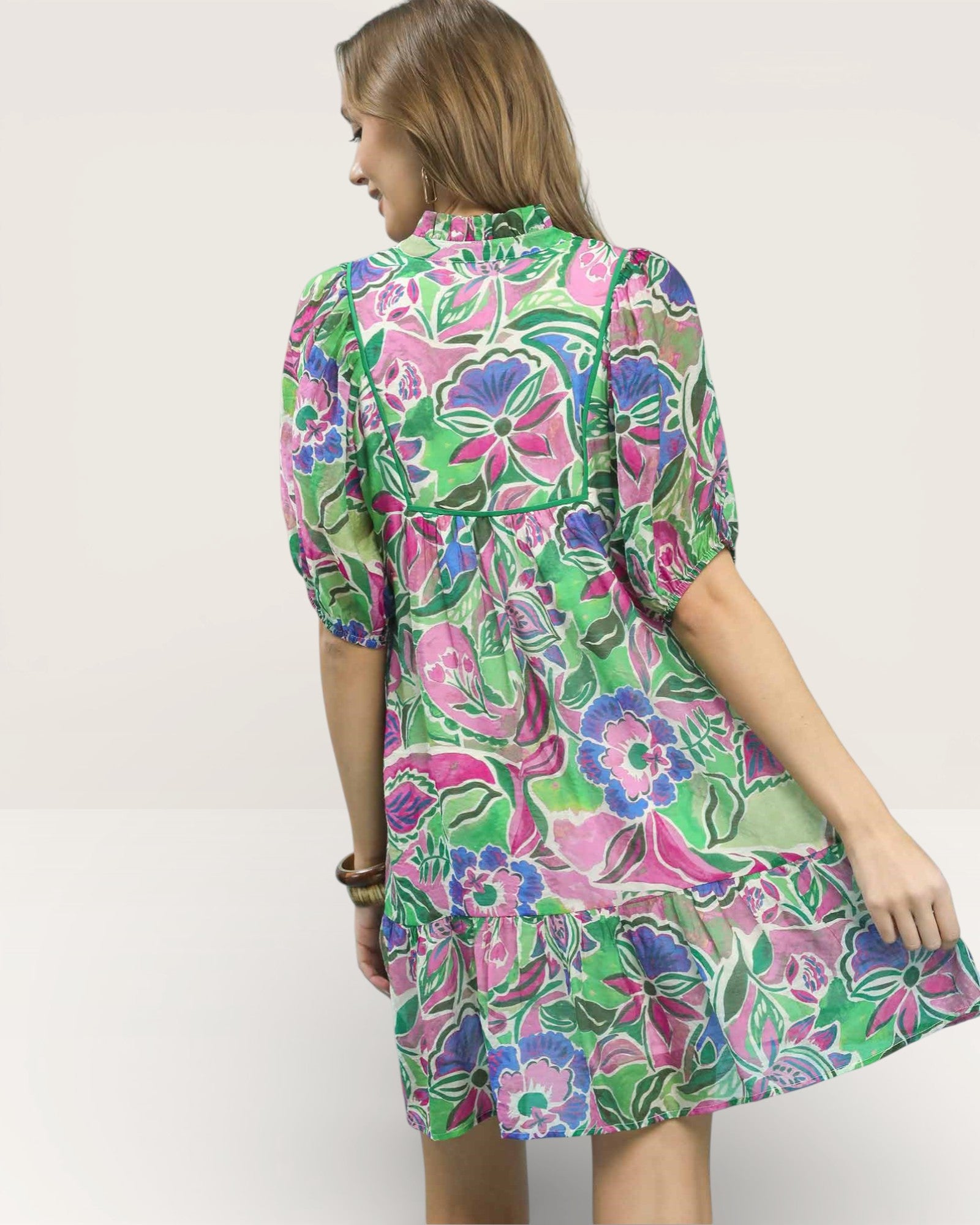 Woman wearing a colorful floral dress on a white background
