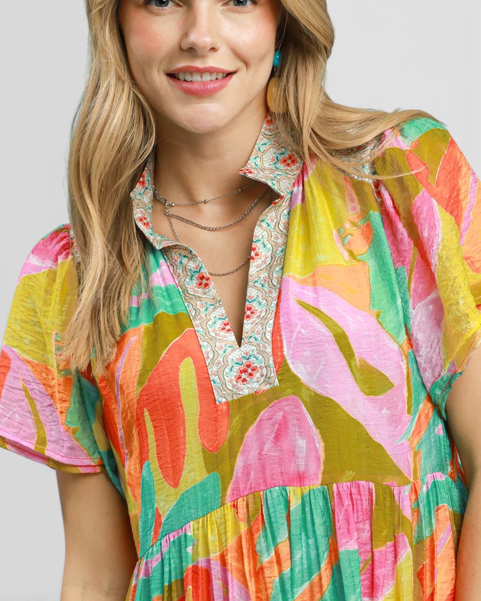 Woman wearing a colorful floral dress with a plain background