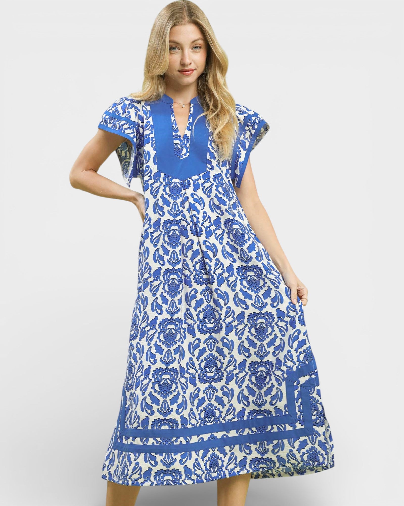 Woman wearing a blue and white floral dress on a light gray background