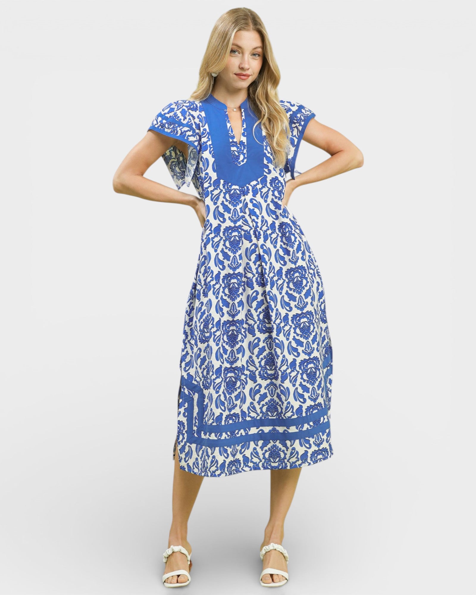Woman wearing a blue and white floral dress on a white background