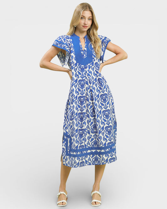 Woman wearing a blue and white floral dress on a white background