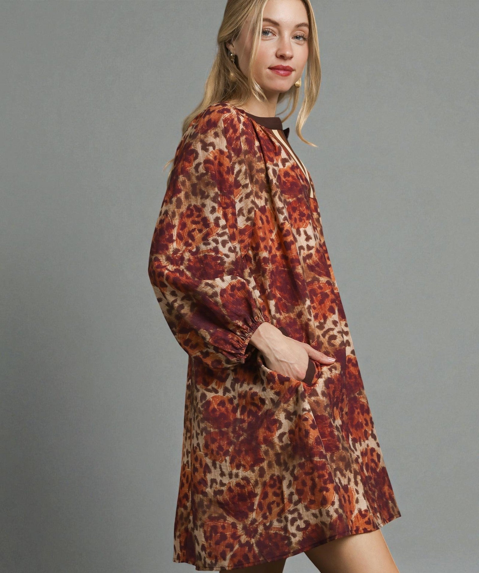 Woman wearing a leopard print dress against a gray background