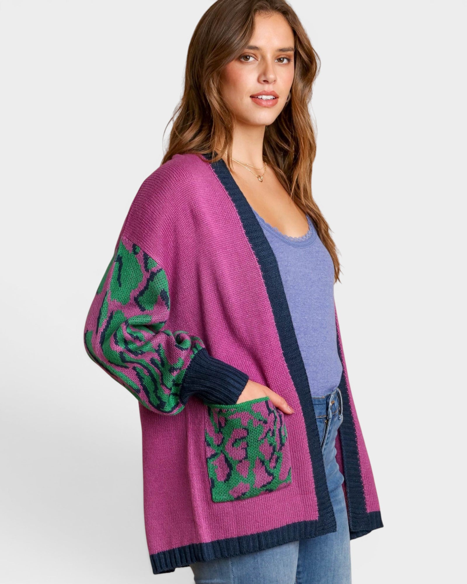 Woman wearing a purple cardigan with green patterns on a white background