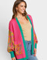 Woman wearing a colorful cardigan with a pink and green pattern on a white background