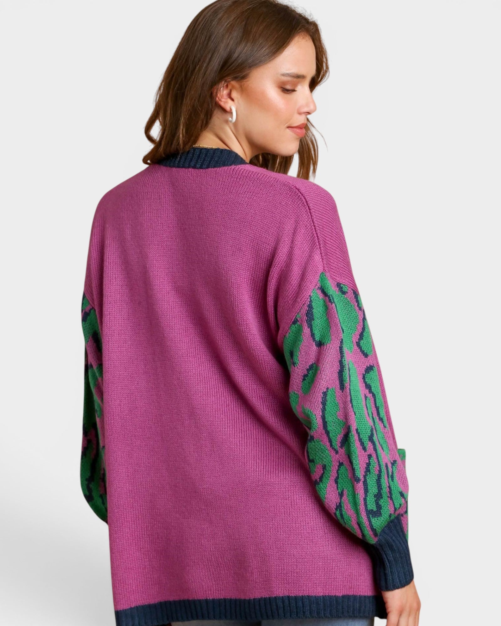 Purple sweater with green leaf patterns on a white background