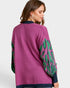 Purple sweater with green leaf patterns on a white background