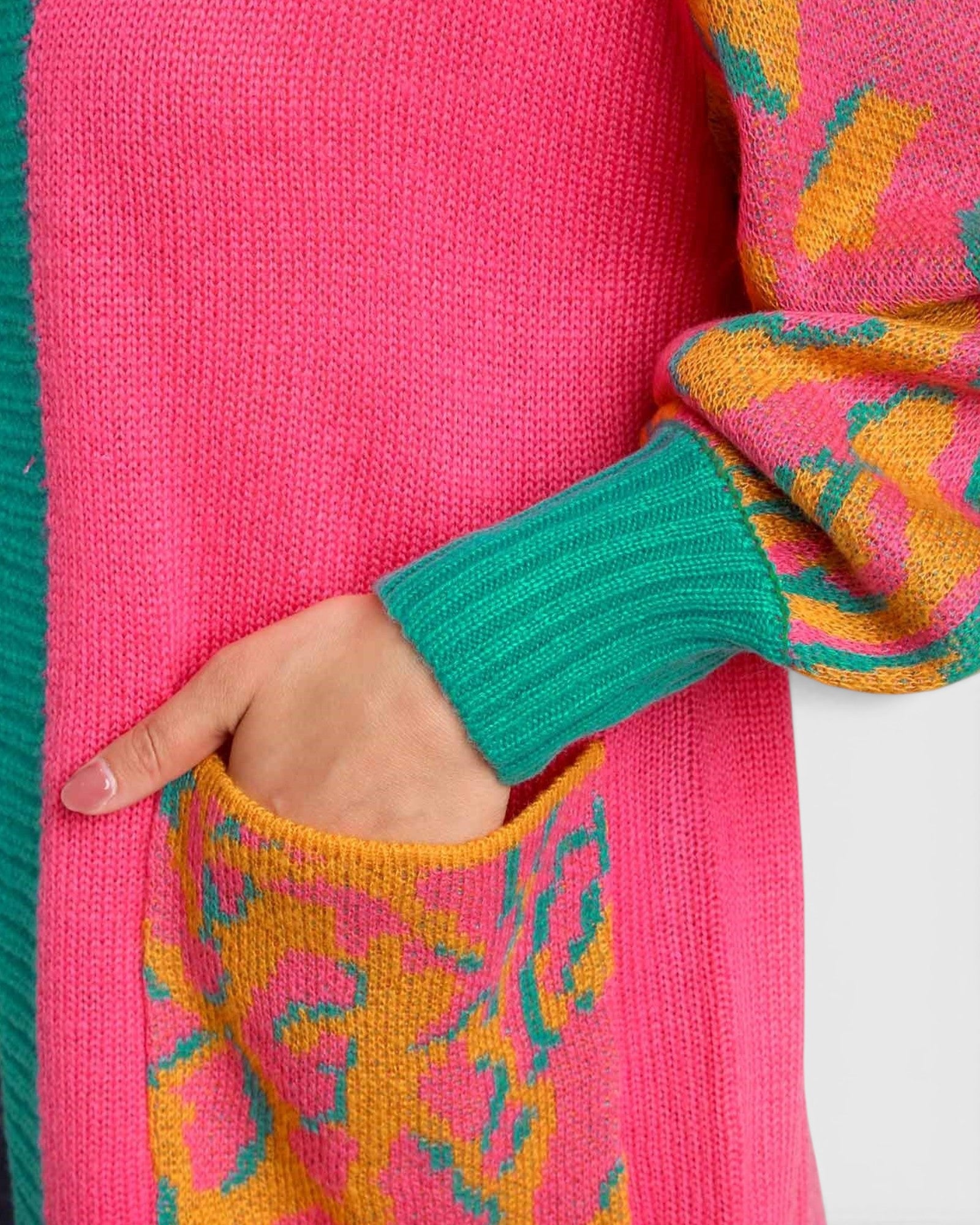 Close-up of a colorful sweater with pink, green, and orange patterns.