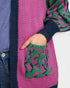 Close-up of a person wearing a colorful sweater with a patterned pocket.