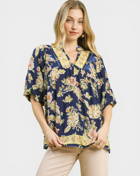 Woman wearing a floral patterned blouse on a plain background