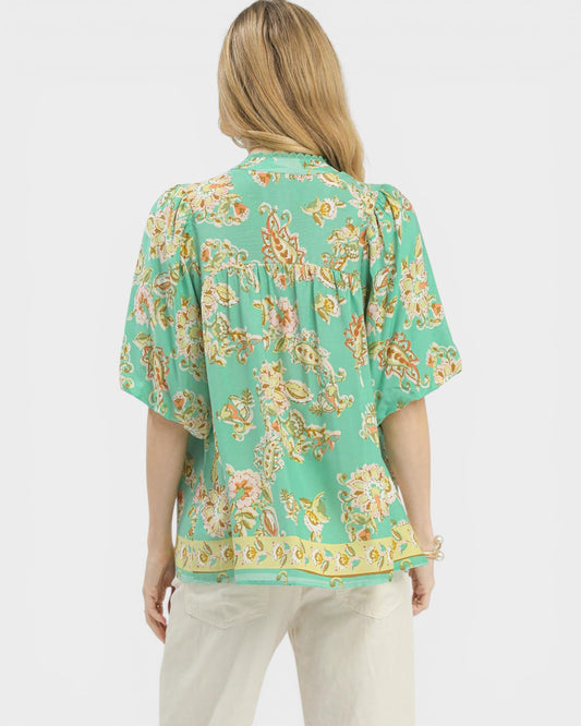 Woman wearing a green floral blouse on a white background