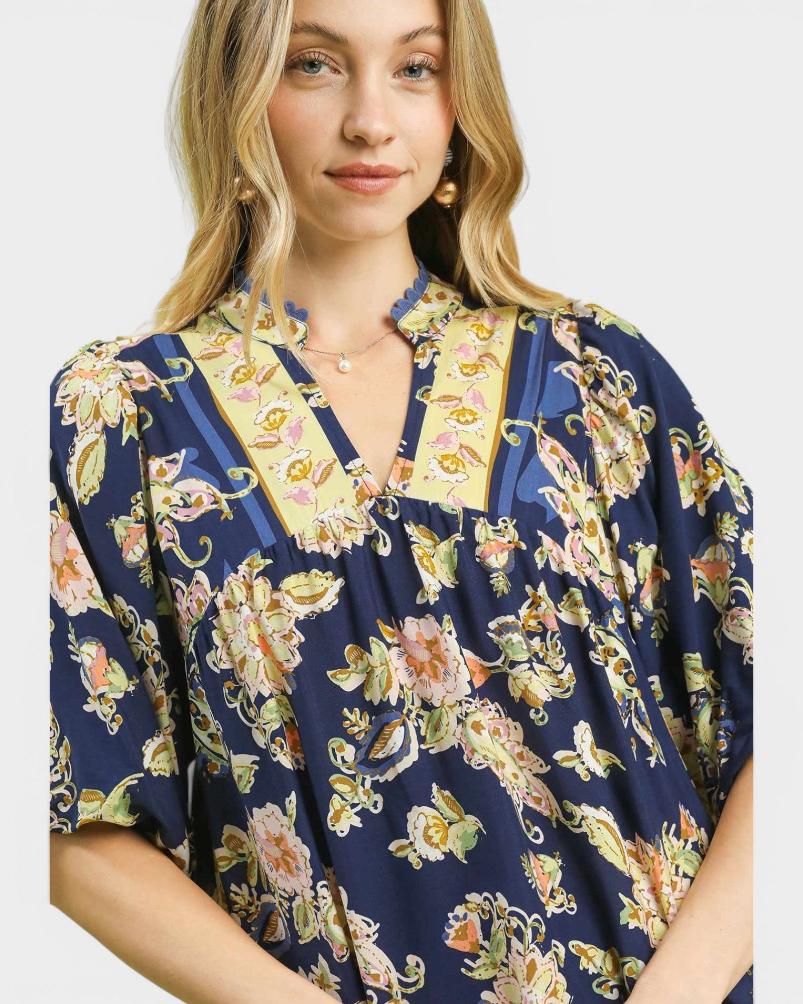 Woman wearing a floral patterned blouse with a plain background