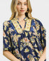 Woman wearing a floral patterned blouse with a plain background