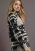 Woman wearing a patterned sweater against a plain background