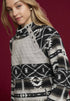 Woman wearing a patterned sweater with a quilted design on a red background
