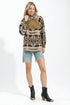 Woman wearing a patterned sweater, denim shorts, and black boots on a white background