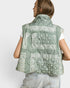 Person wearing a green patterned vest on a white background