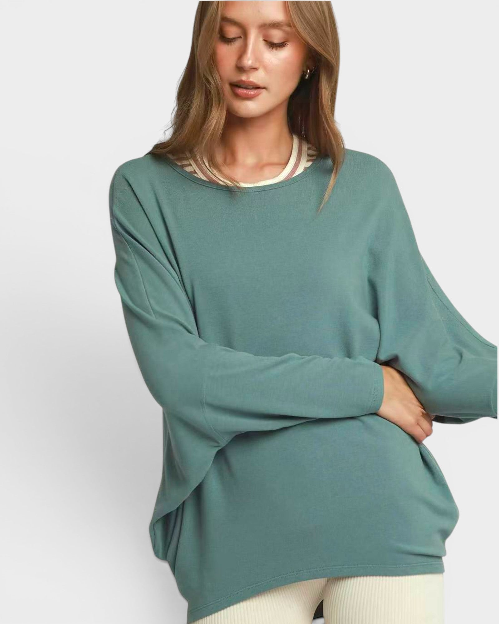 Woman wearing a teal sweater on a white background