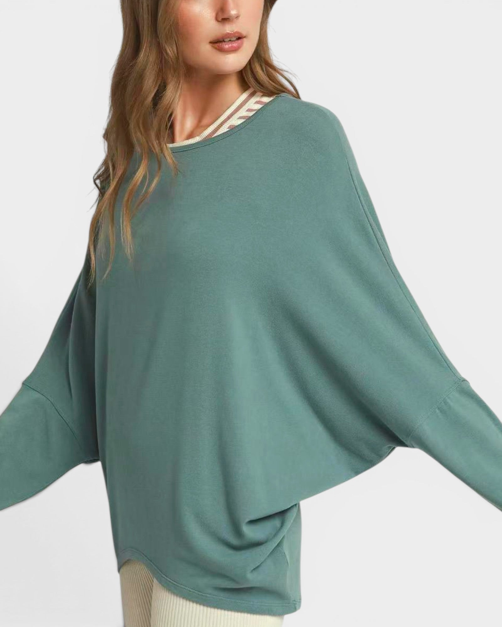 Woman wearing a teal sweater with a white background