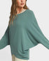Woman wearing a teal sweater with a white background