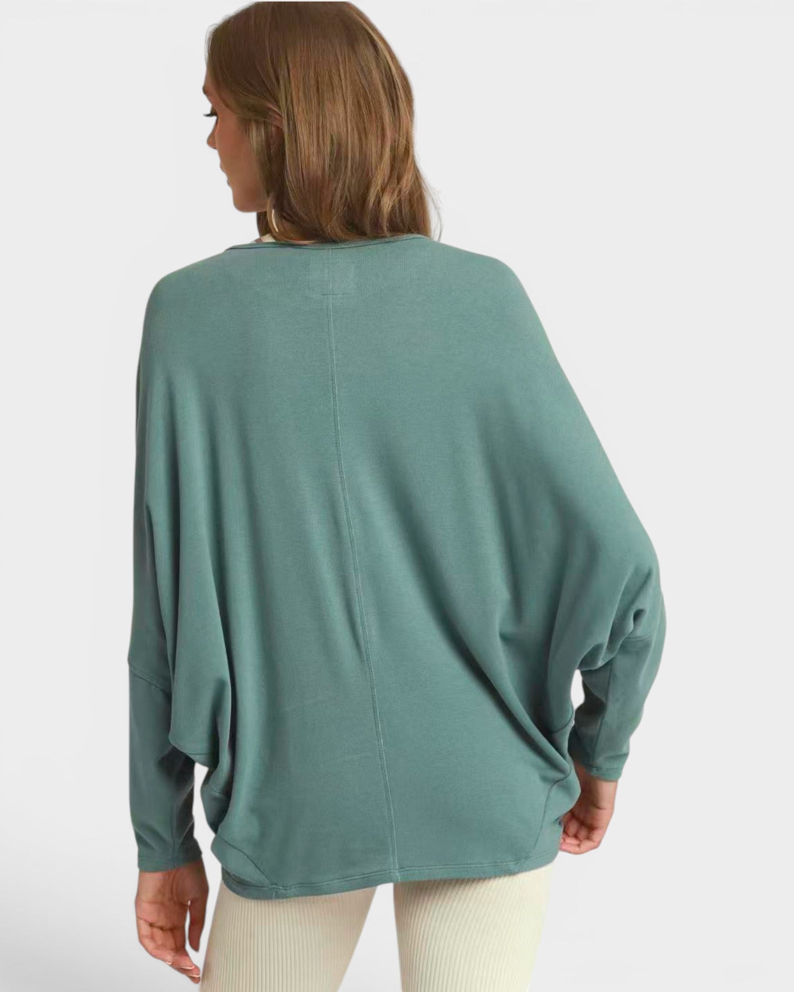 Person wearing a teal sweater on a white background