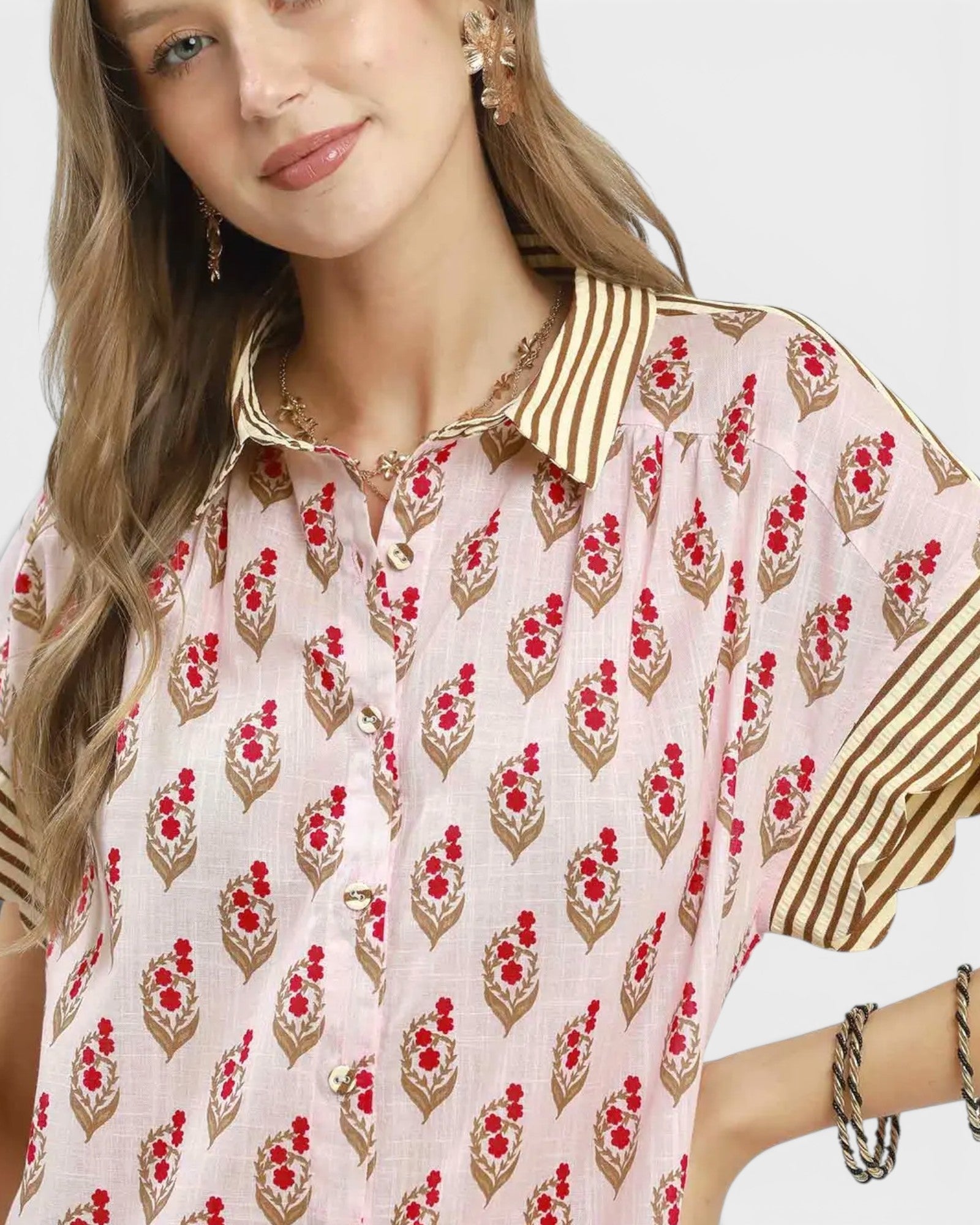 Woman wearing a floral patterned blouse with a neutral background
