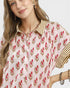 Woman wearing a floral patterned blouse with a neutral background