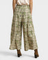 Green patterned wide-leg pants worn by a person on a white background