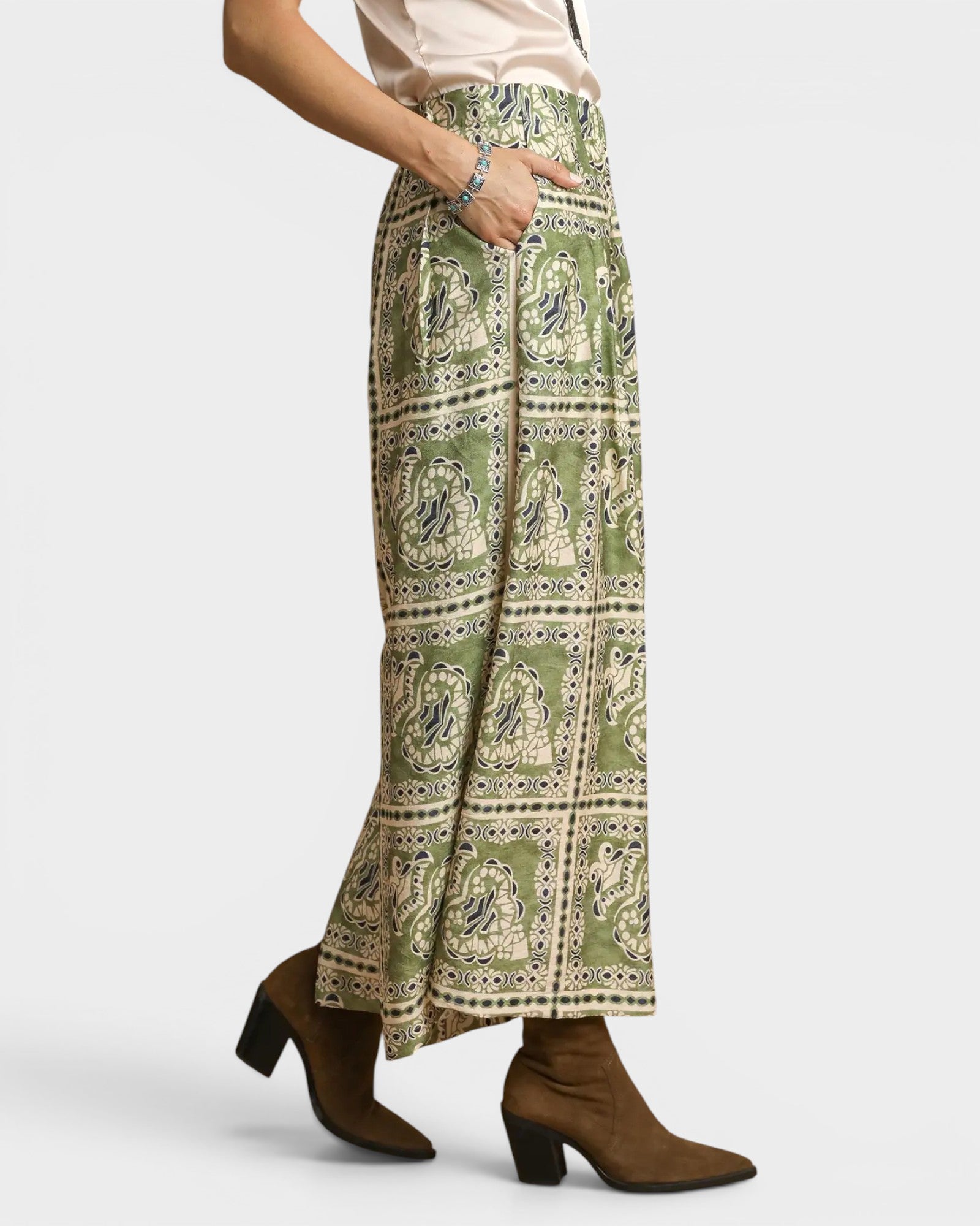 Person wearing a green patterned skirt on a white background