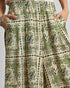 Green patterned skirt with hands in pockets on a neutral background