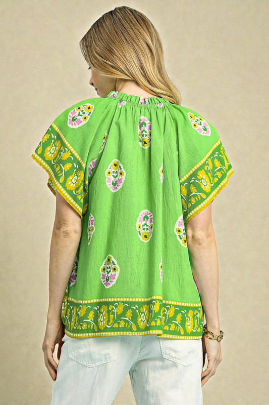 Green blouse with floral patterns on a beige background