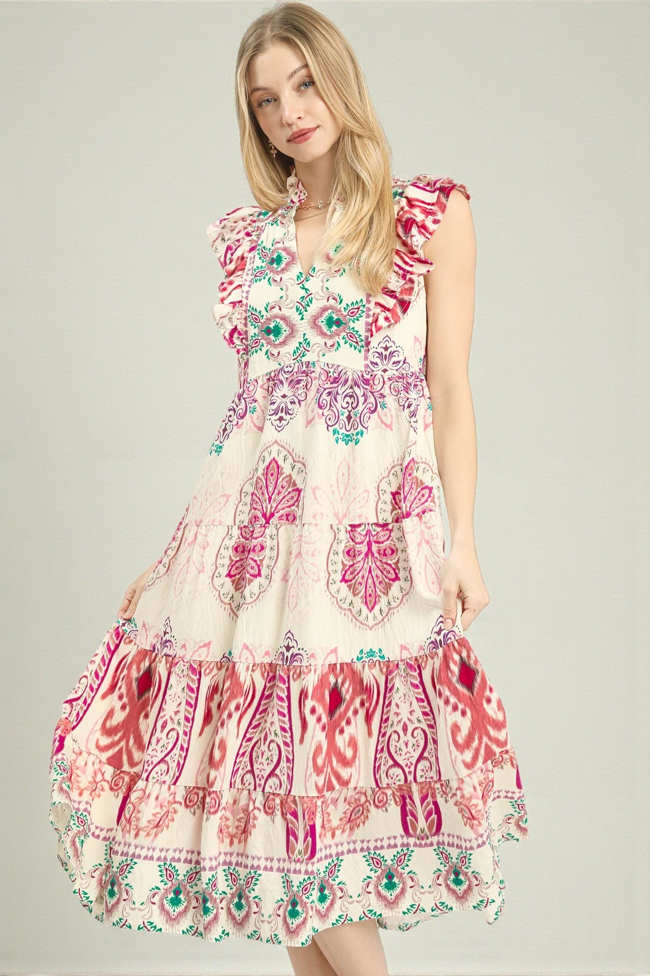 Woman wearing a colorful patterned dress on a plain background