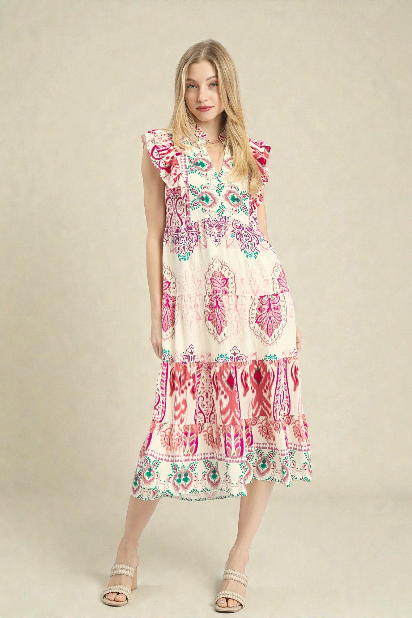 Woman wearing a colorful patterned dress on a beige background