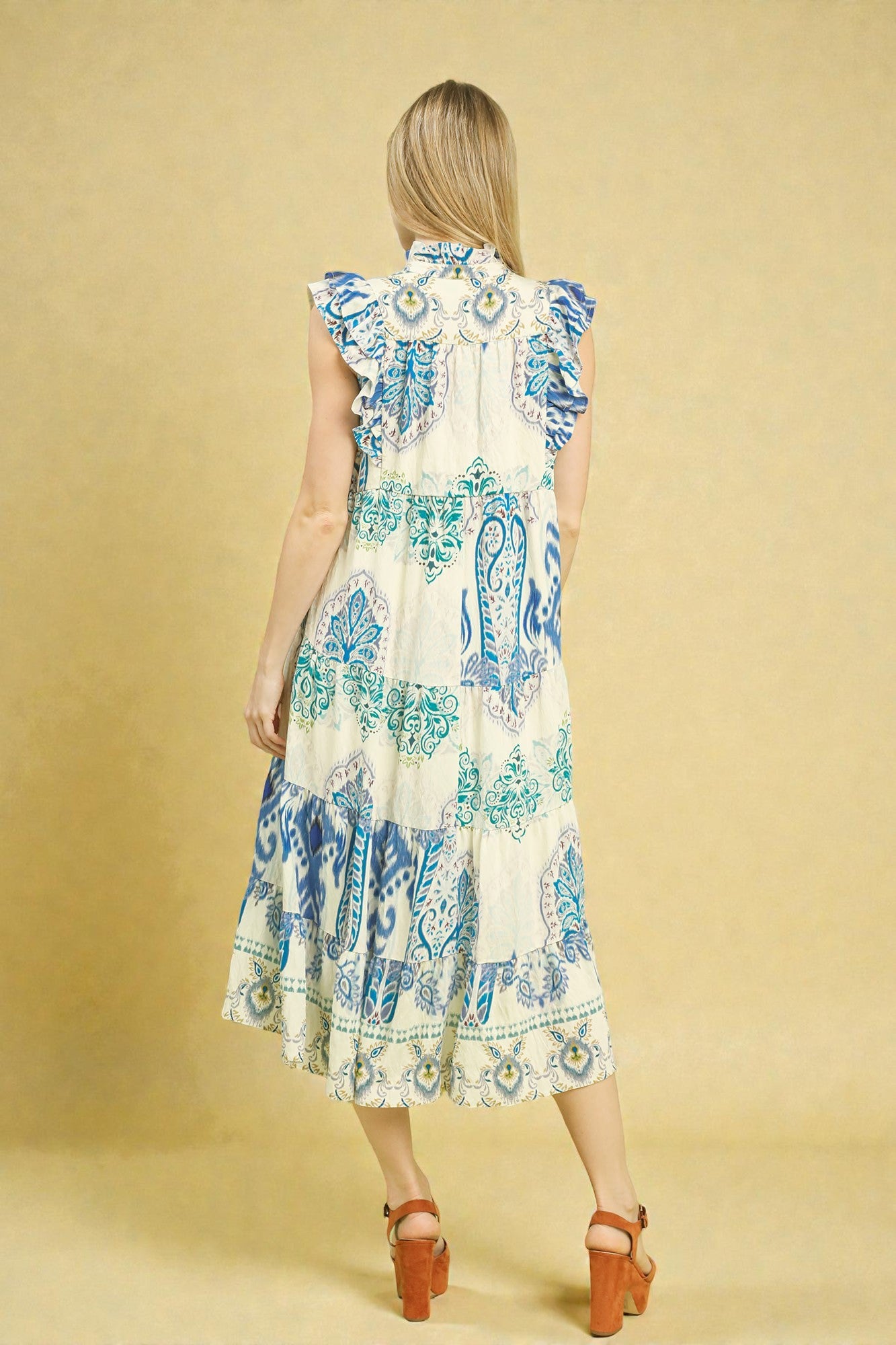 Woman wearing a patterned dress on a beige background