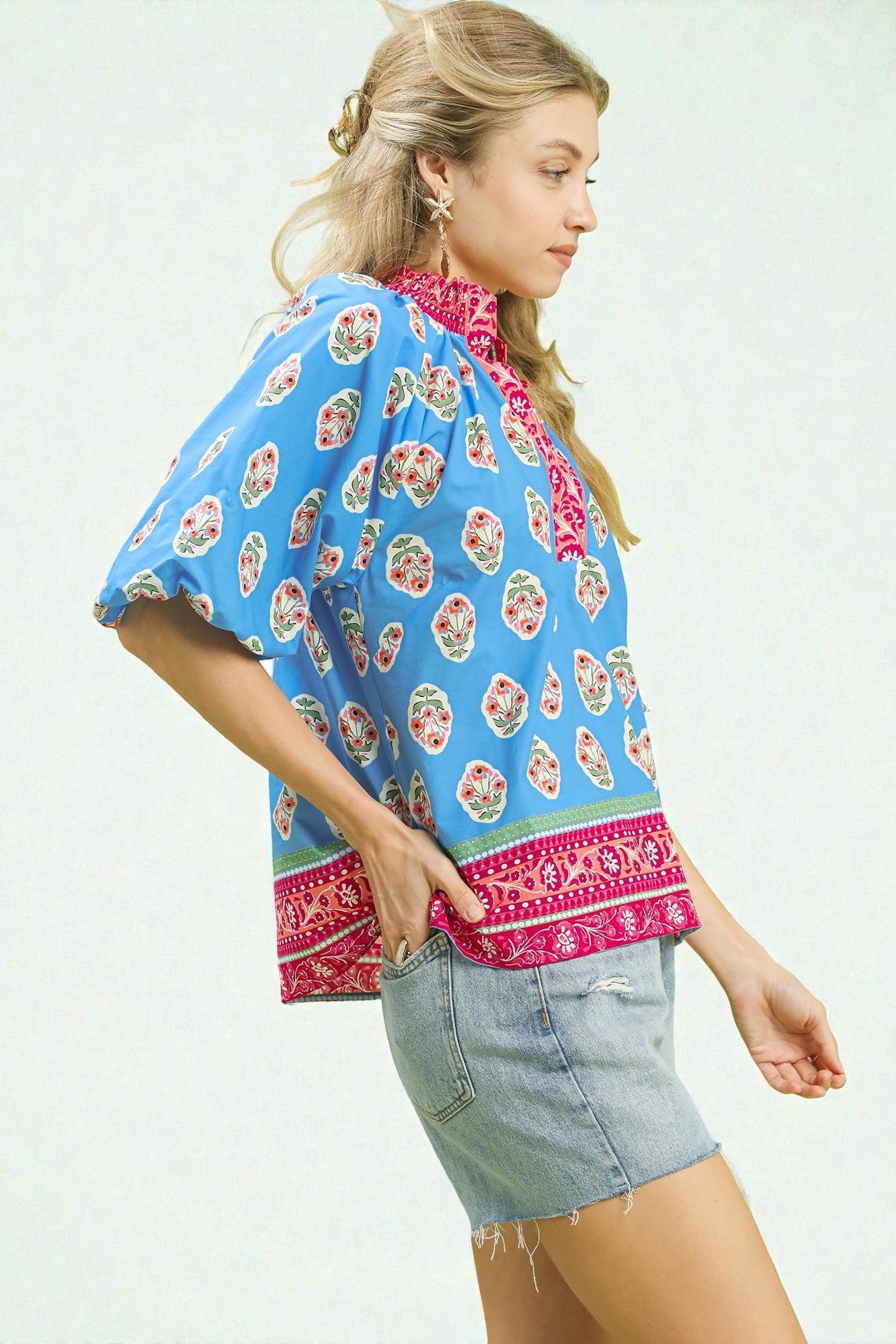 Woman wearing a colorful kimono-style top with floral patterns on a white background