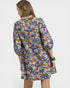 Woman wearing a colorful floral dress on a white background