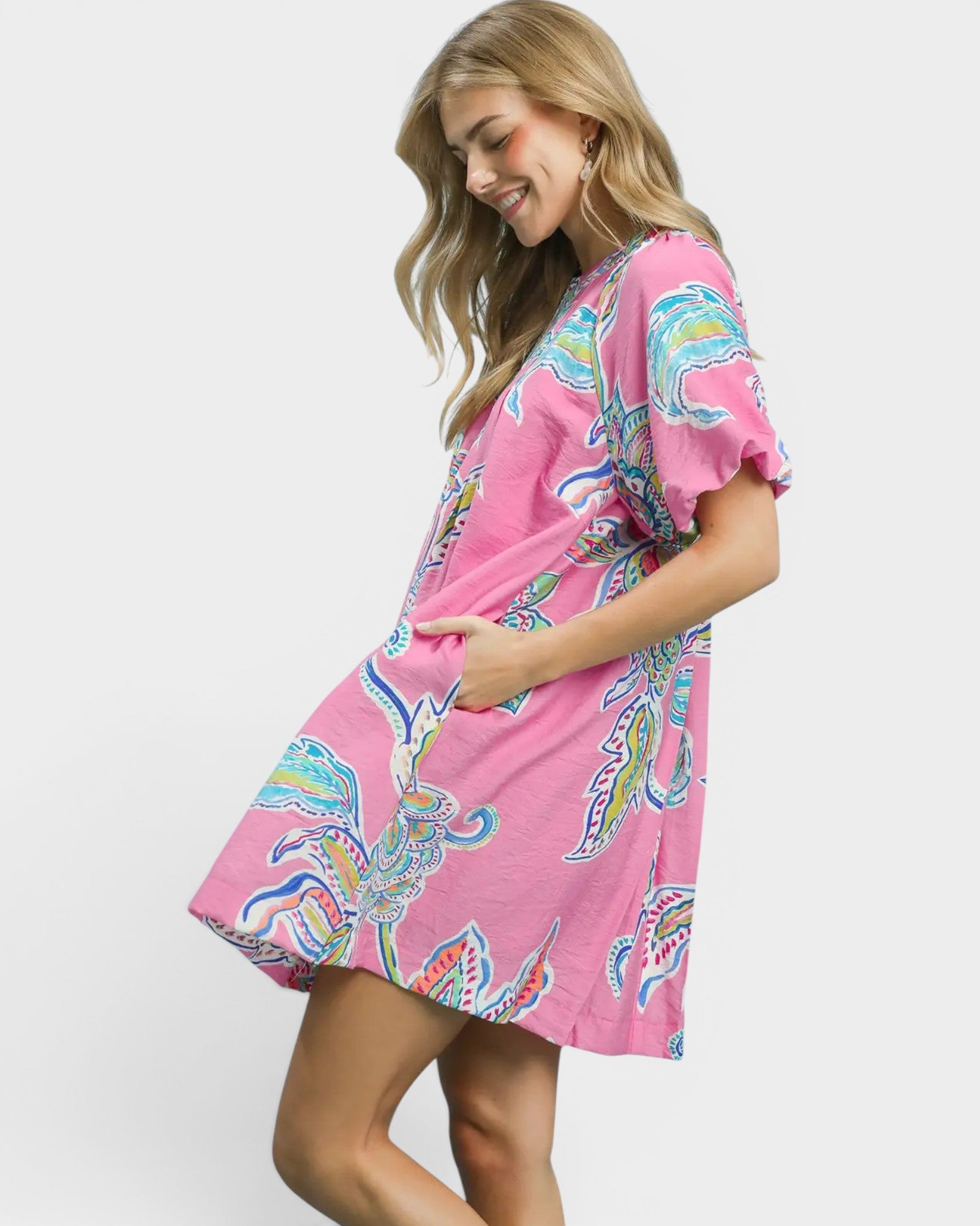Woman wearing a pink patterned dress on a white background