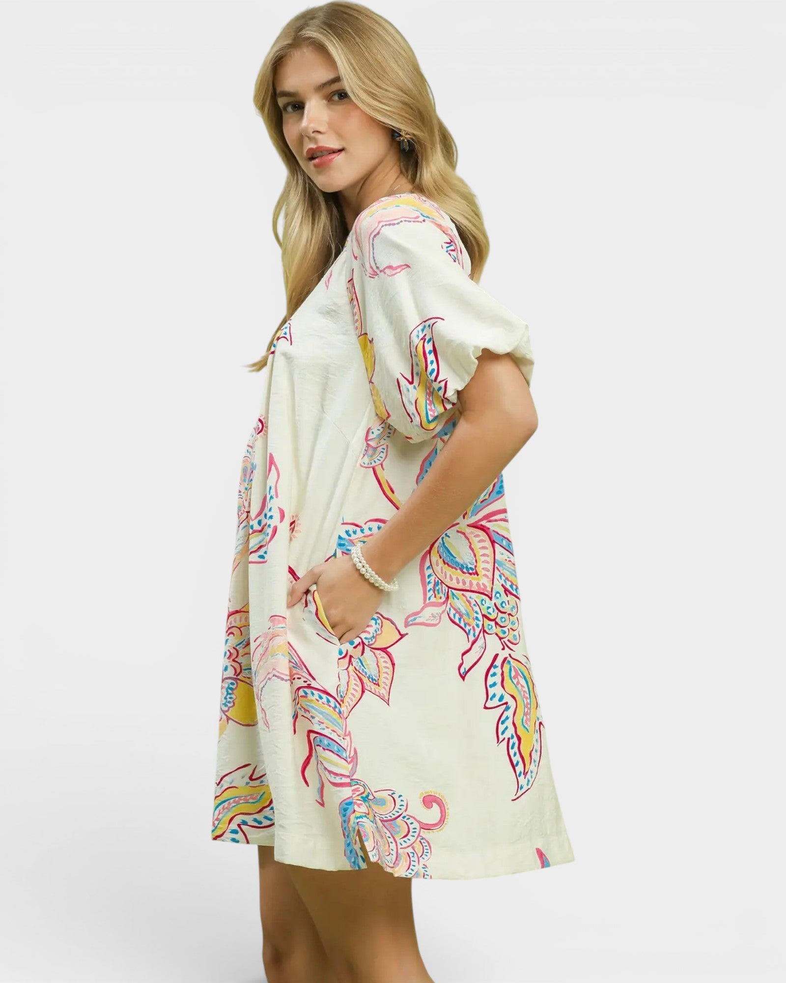 Woman wearing a colorful patterned dress on a white background
