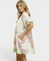 Woman wearing a colorful patterned dress on a white background