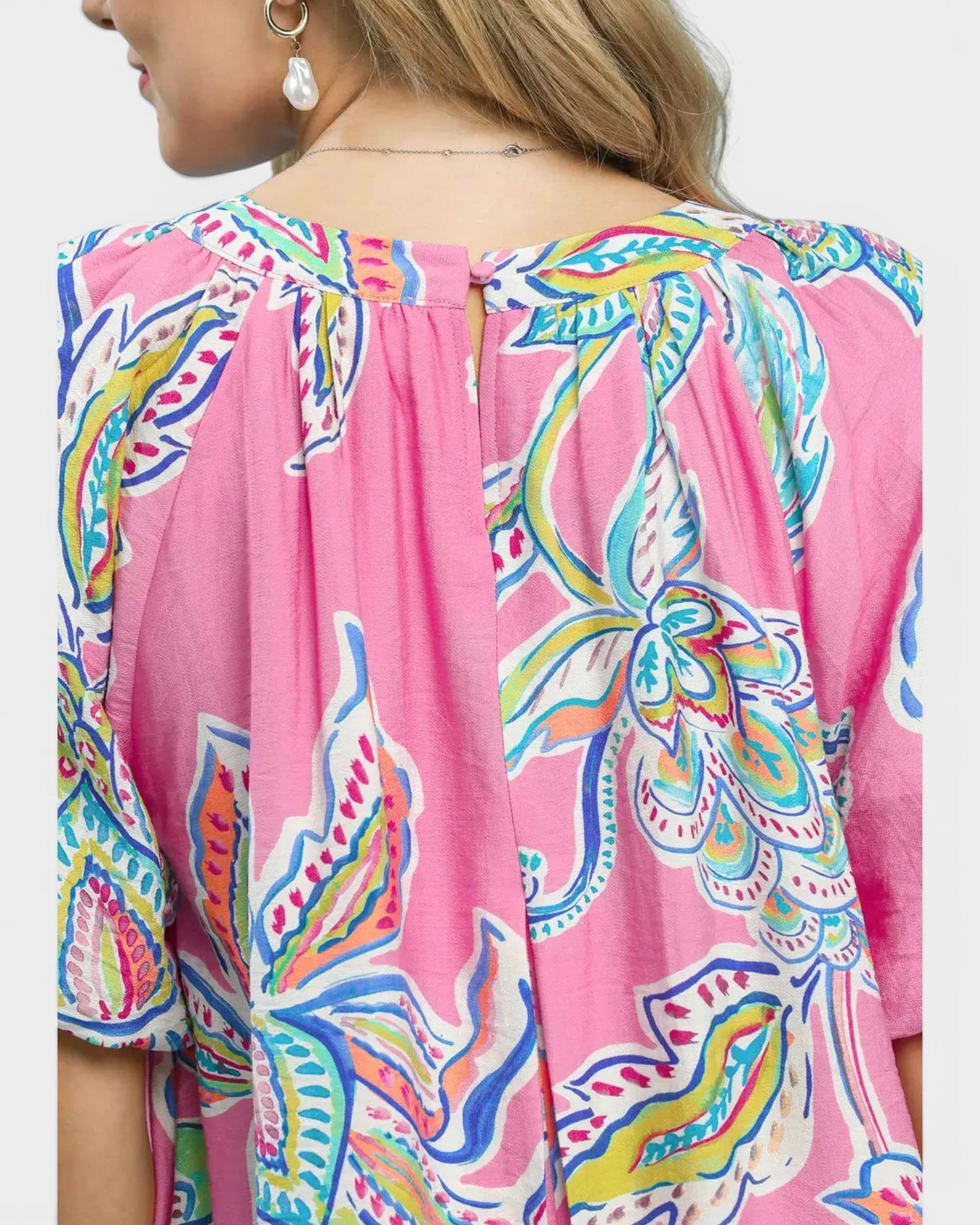 Close-up of a colorful patterned dress with a pink background