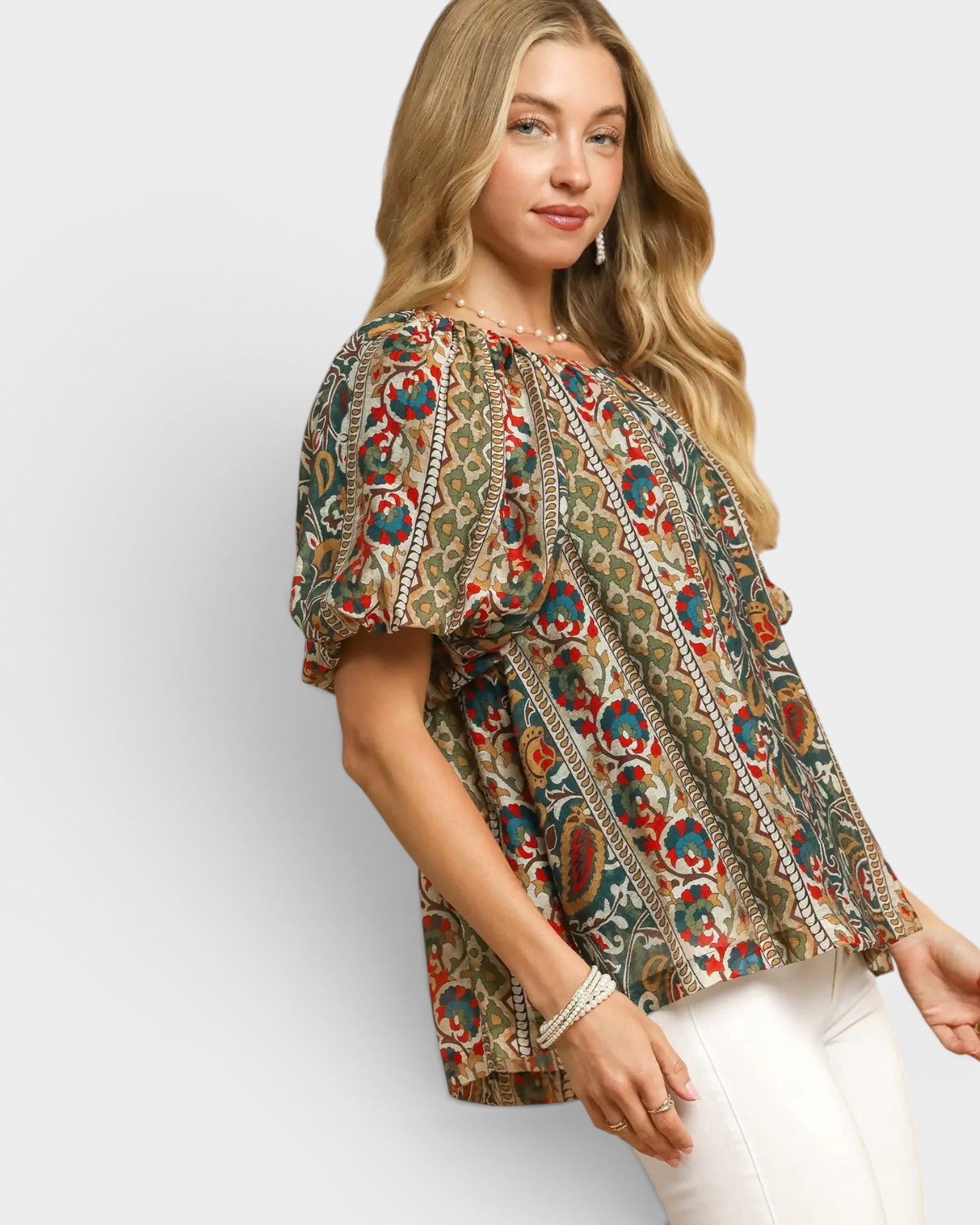Woman wearing a patterned blouse with a plain background